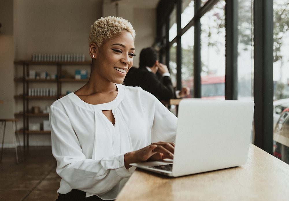 Happy businesswoman in a cafe using her laptop