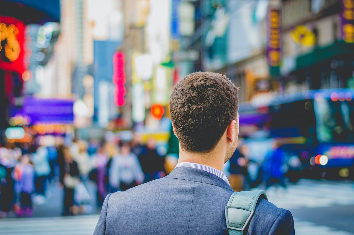 young man standing on a busy road