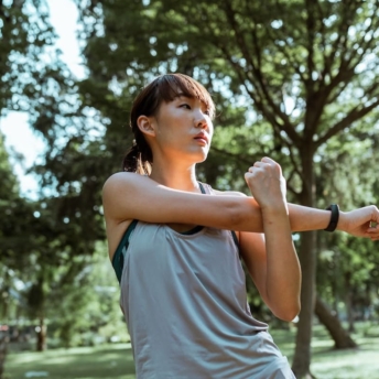 Woman stretching in the park as a weight loss exercise habit