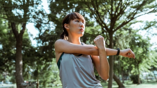 Woman stretching in the park as a weight loss exercise habit