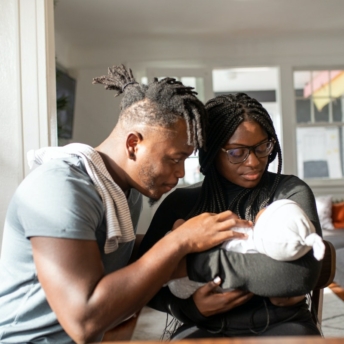 Parents hold their newborn baby