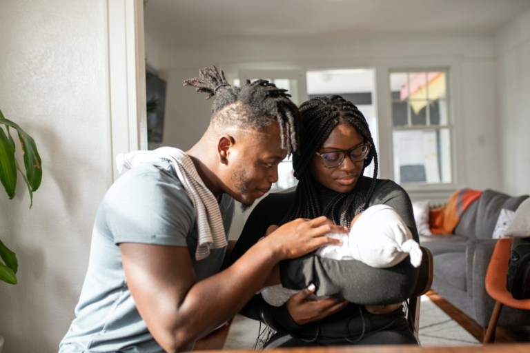 Parents hold their newborn baby