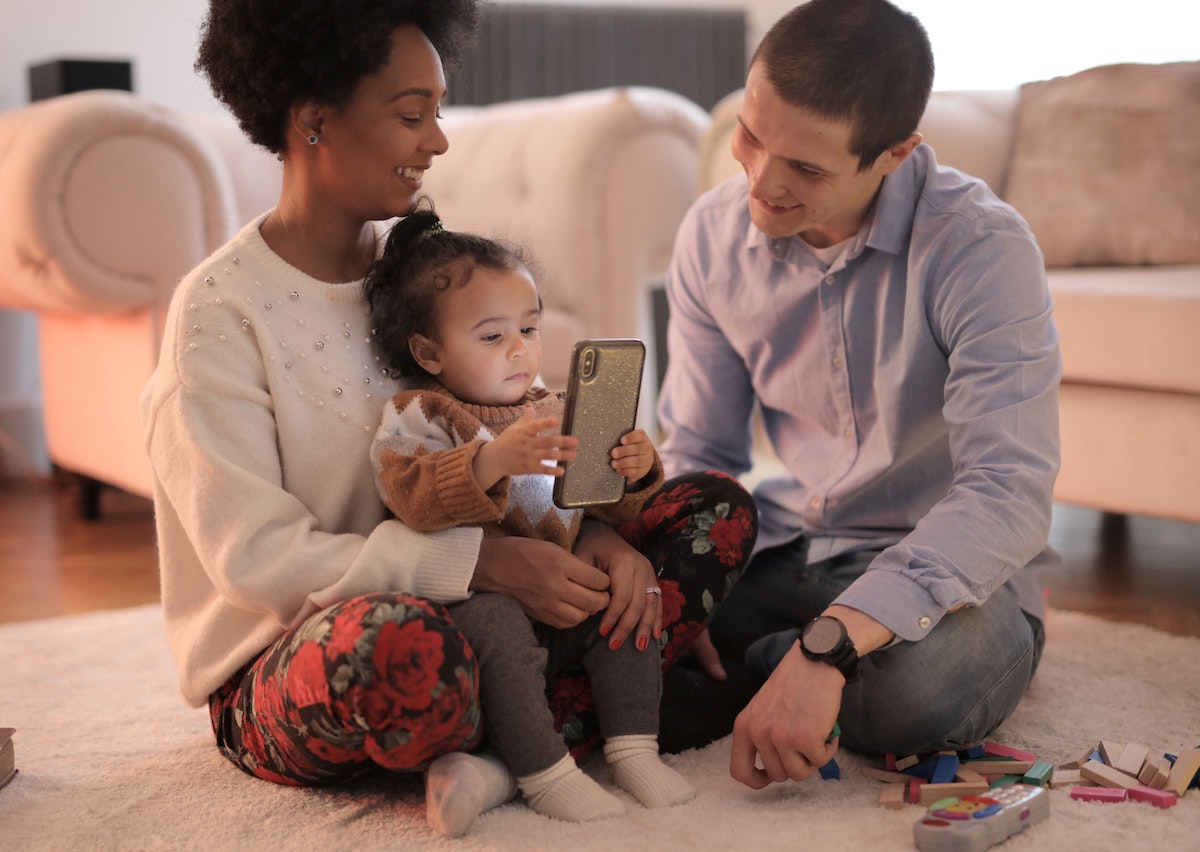Parents allowing their child to play with a gadget using permissive parenting