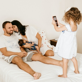 Daughter taking picture of parents and younger sibling