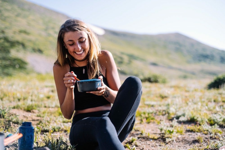 Woman eating less while on a hike in nature