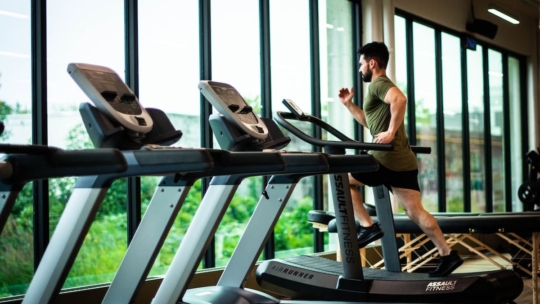 Man running on a treadmill showing how to lose weight in a month