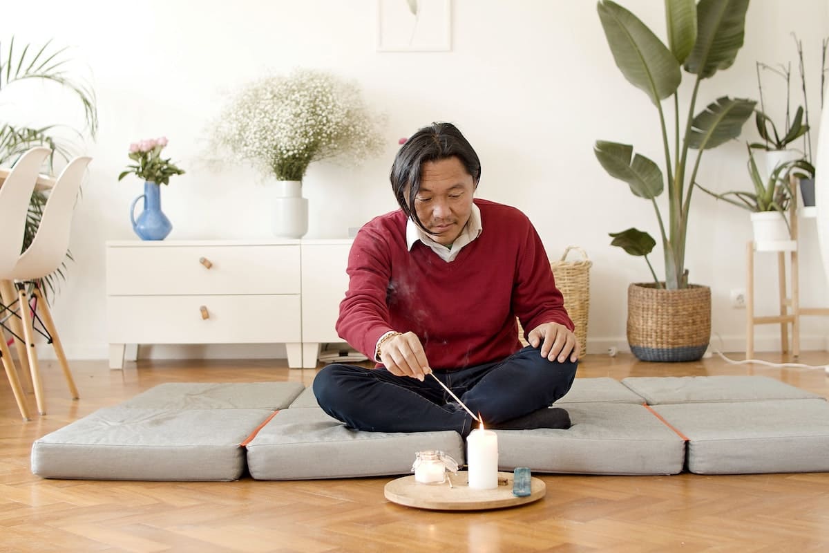 Man lighting up the flame for a candle meditation