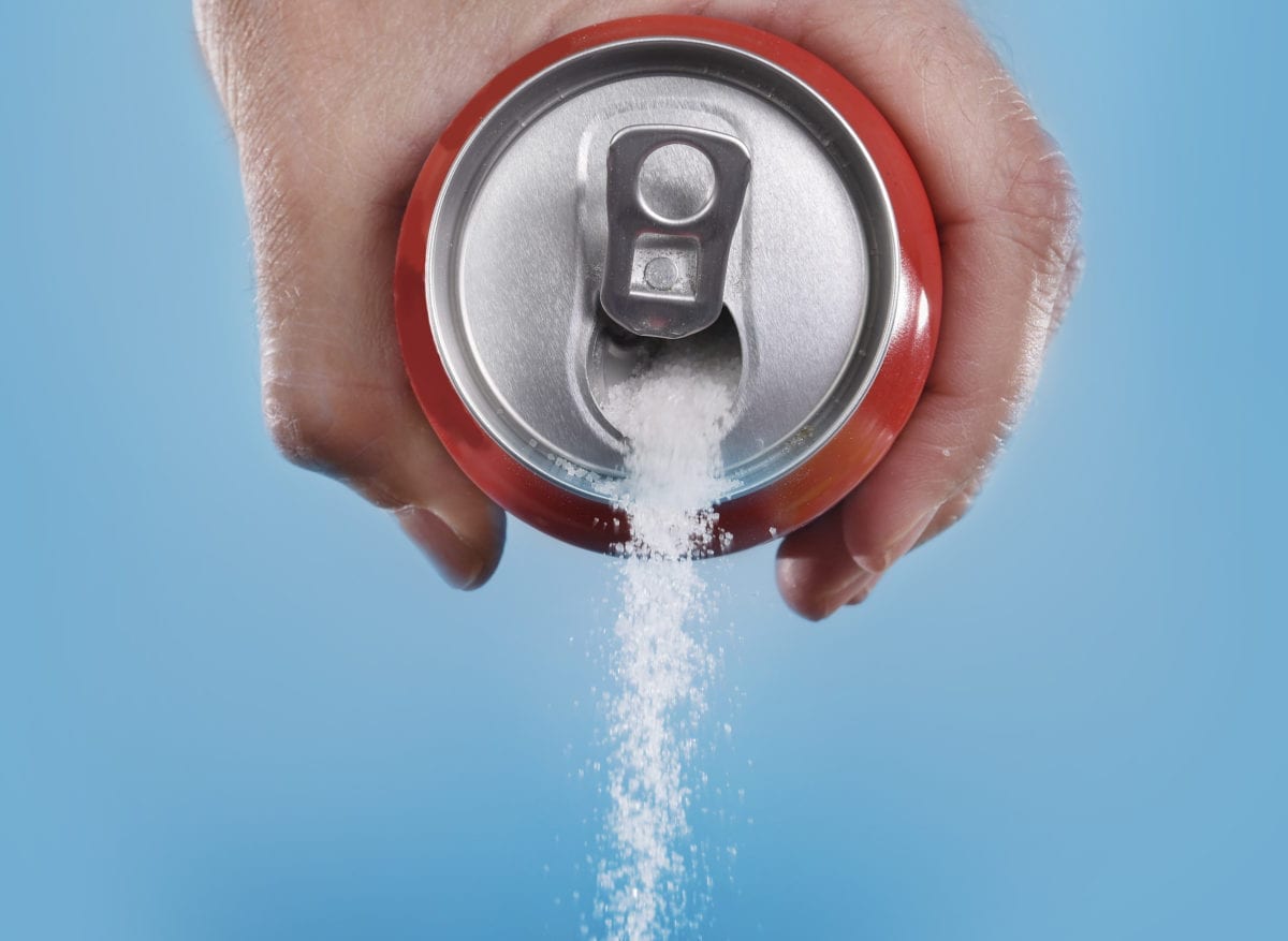 A can of coca-cola pouring out sugar