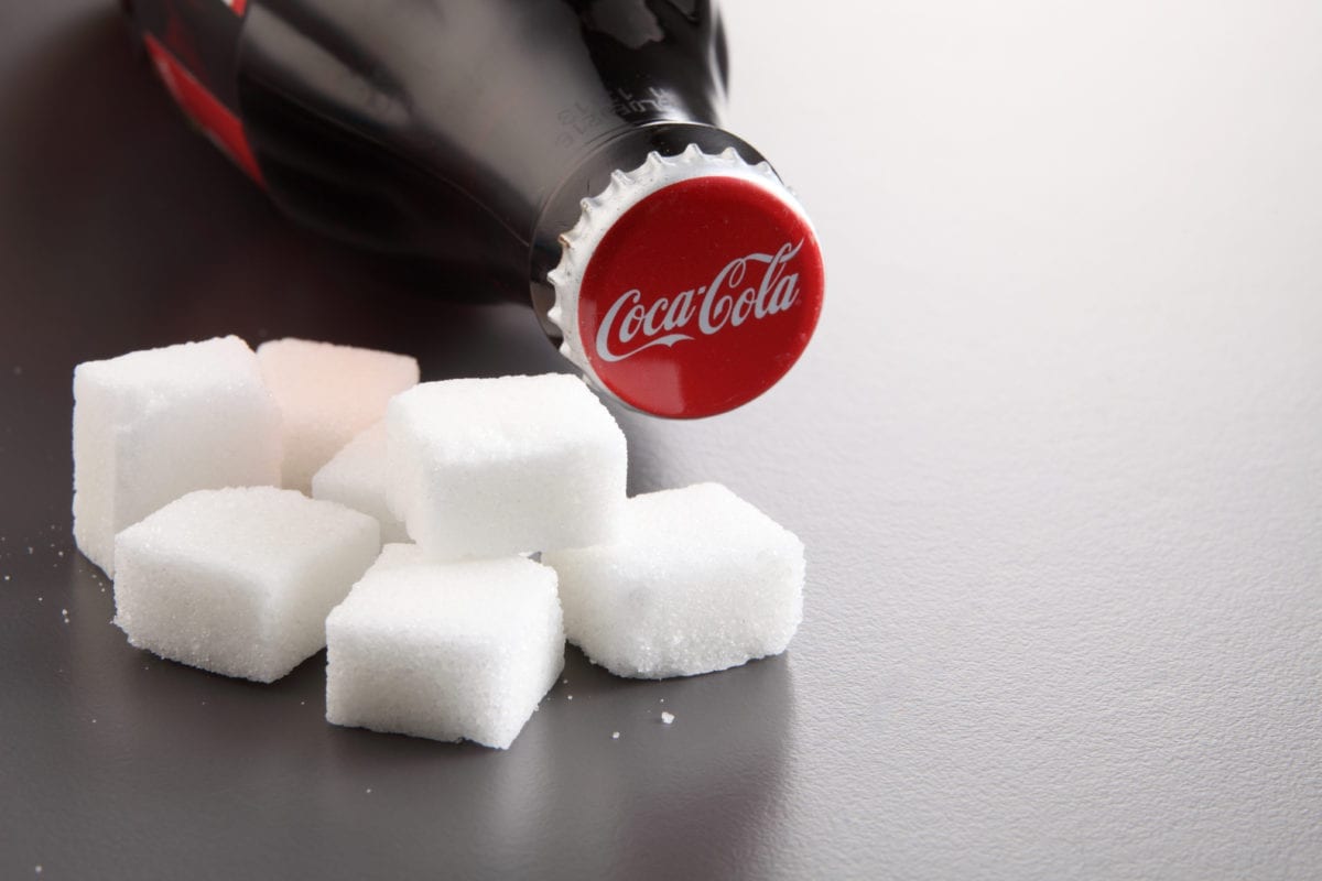 A bottle of coca-cola and sugar cubes