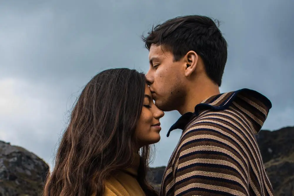 Man kissing his girlfriend on the forehead