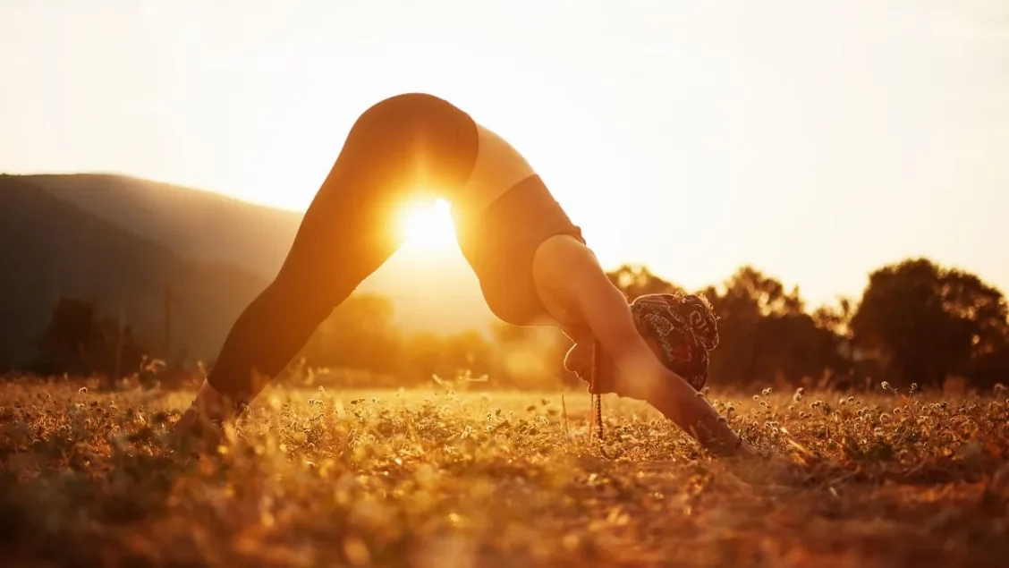 Woman doing a downward dog yoga pose for her solar plexus chakra