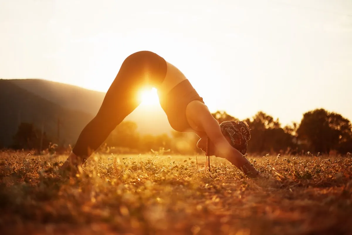 Woman doing a downward dog yoga pose for her solar plexus chakra