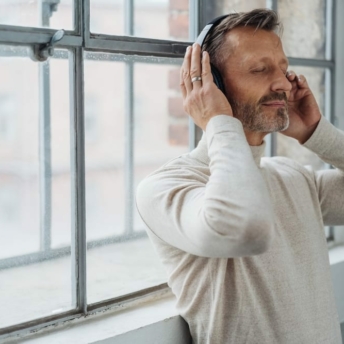 Man listening to personal growth podcasts on headphones