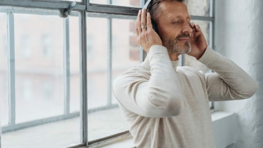 Man listening to personal growth podcasts on headphones