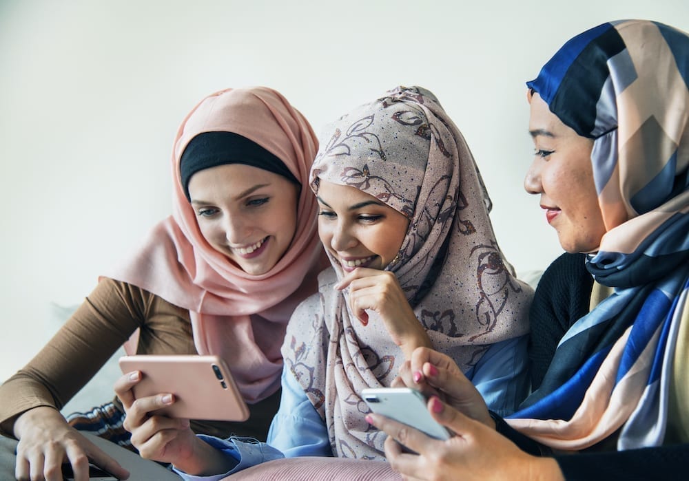Group of islamic women talking and watching on the phone together