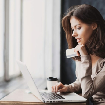 Woman with credit card in front of laptop