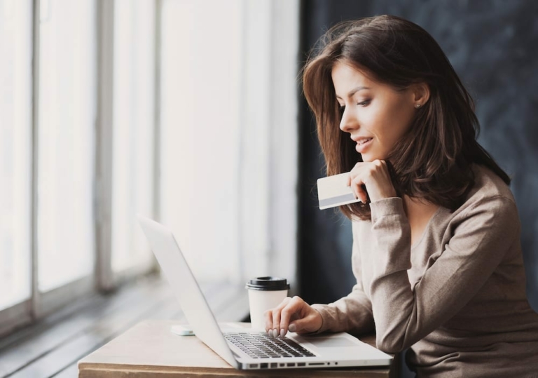 Woman with credit card in front of laptop