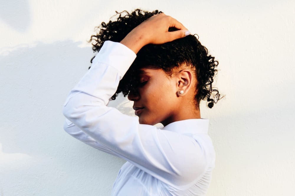 Woman with hair covering face thinking about abundance