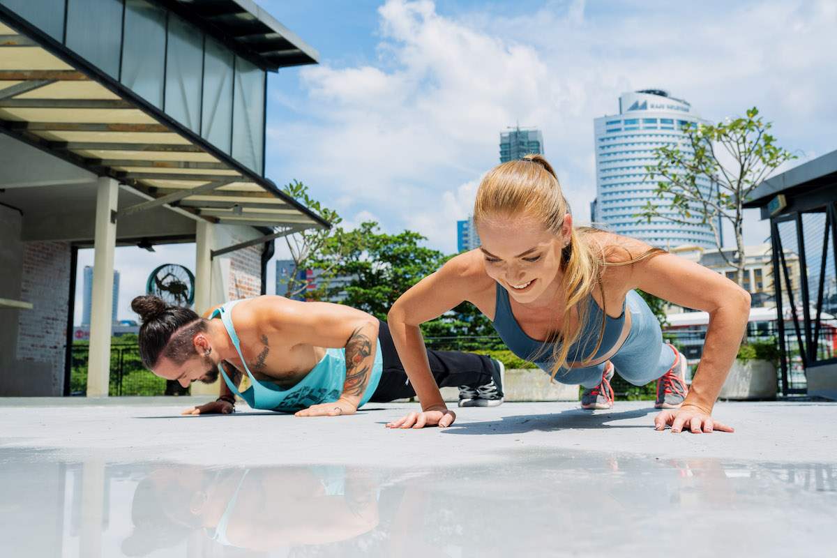 Ronan Diego and Monique Schuldt, trainers of Mindvalley's 10X Quest, doing push-ups