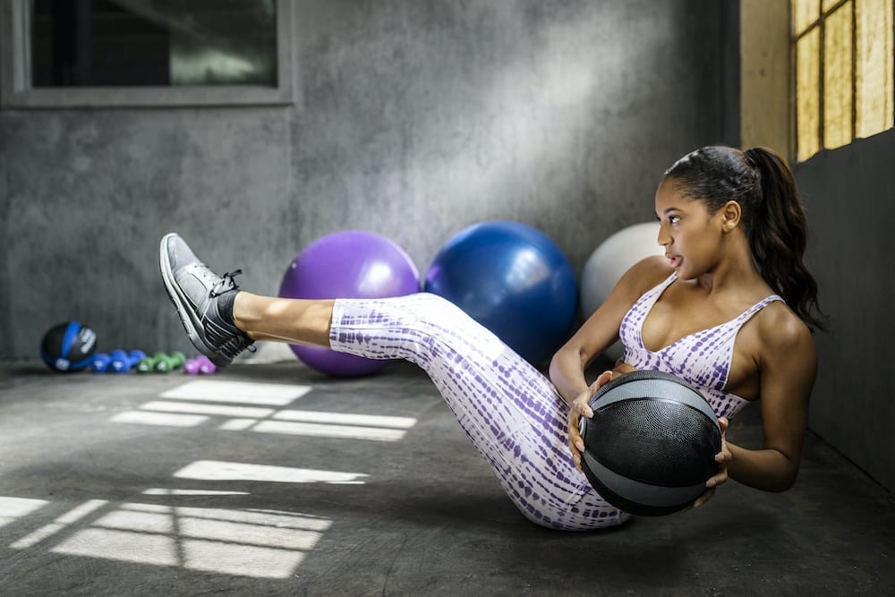 Sportive woman doing workout using a medicine ball