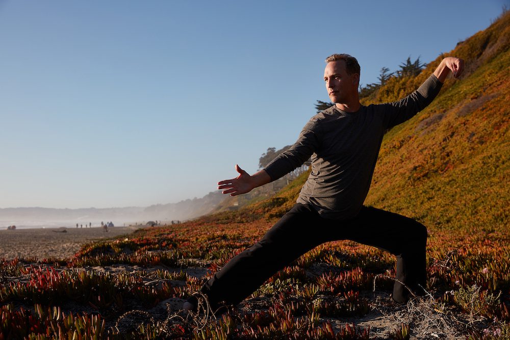 Lee Holden doing qigong exercises on the beach