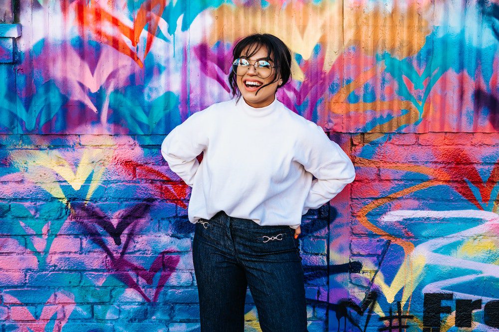 Woman standing in front of a colorful wall with her life unstuck