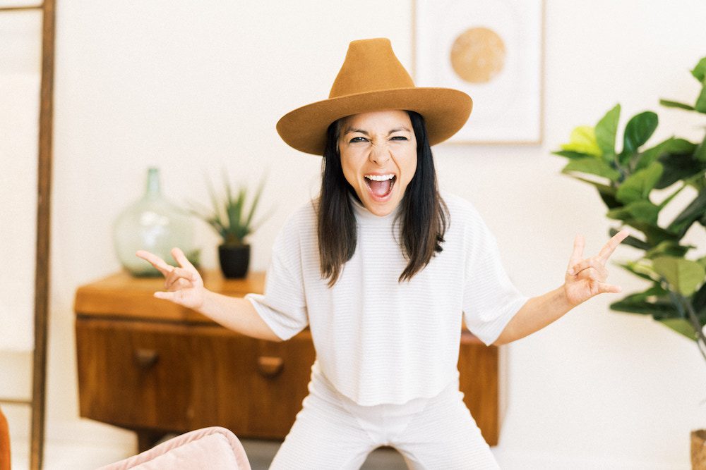 Miki Agrawal holding up peace signs at Mindvalley's Zero to $100 Million Quest