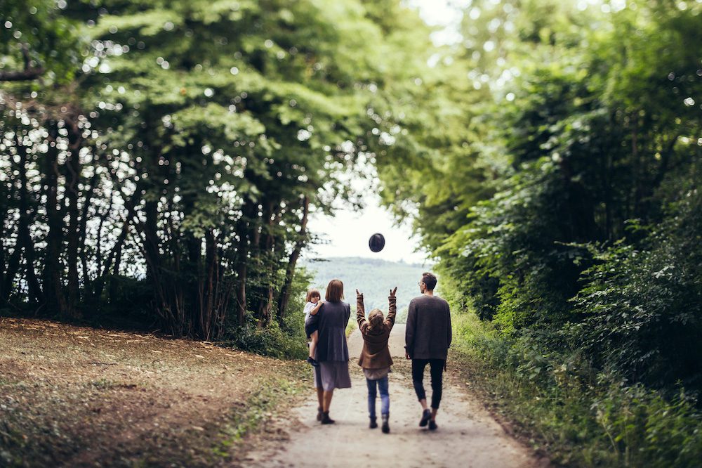 Family walking on a road in the forest