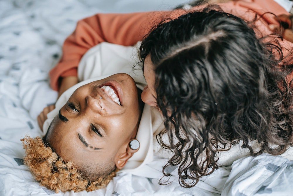 Young couple hugging while lying down in bed