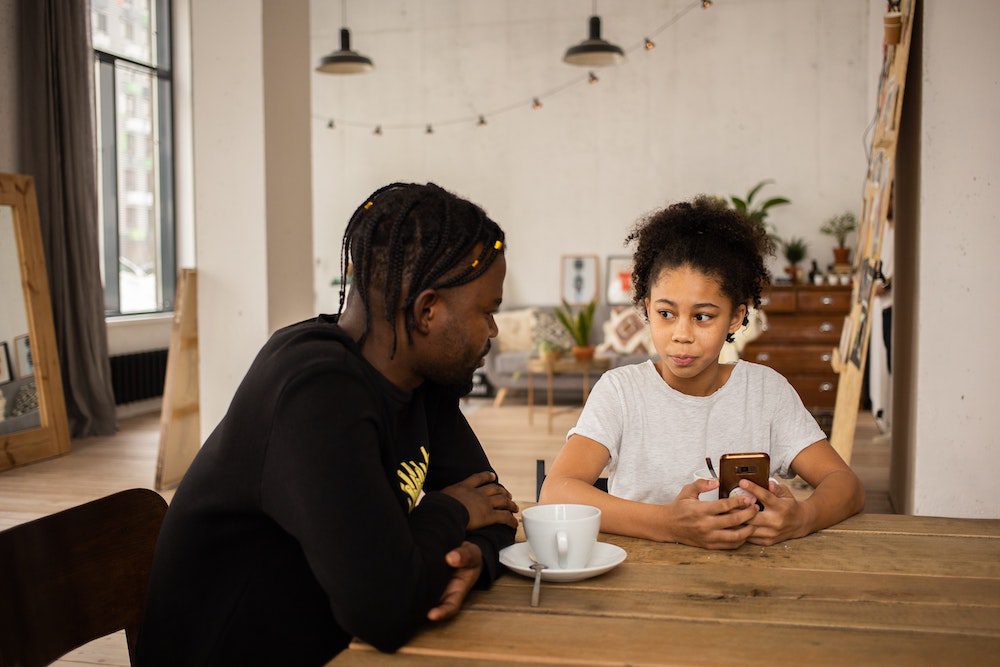 Dad having the sex talk with his child at the dining table