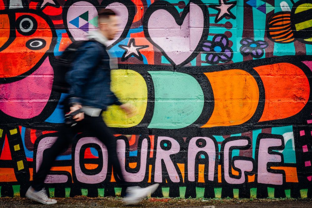 Man walking in front of a colorful wall