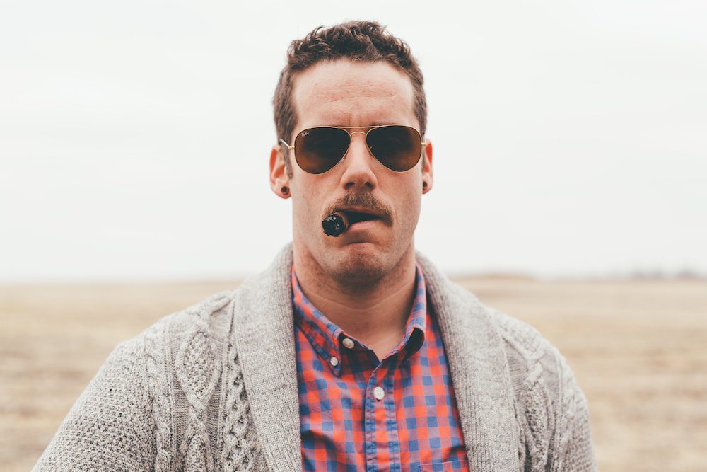 Man smoking a cigar, wearing sunglasses, and acting like a covert narcissist