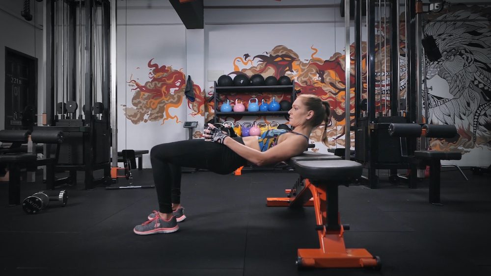 Woman doing dumbbell help thrust as a glute activation workout