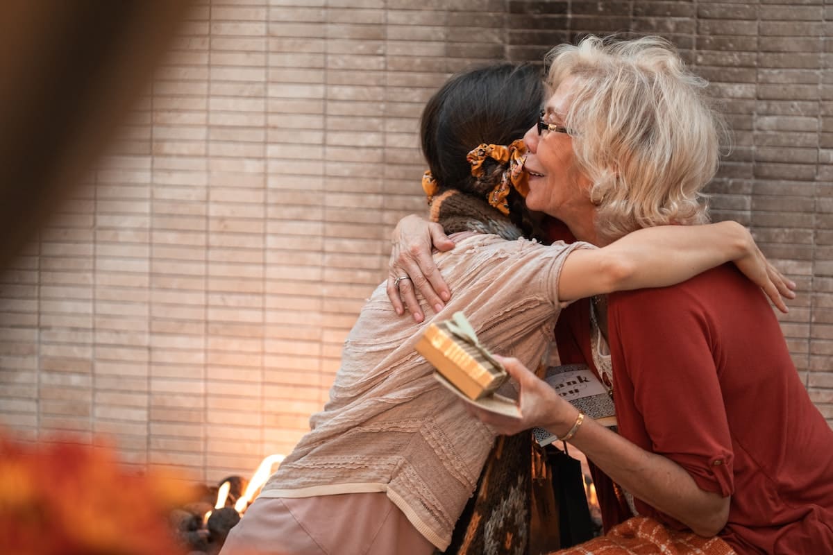 a girl hugging her elderly mother