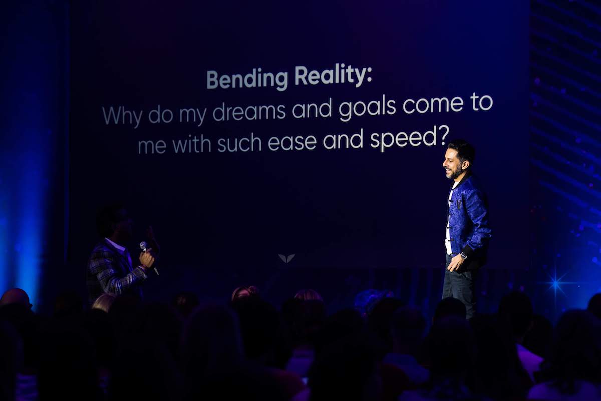 Vishen, founder of Mindvalley and author of The 6 Phase Meditation Method, on stage at Mindvalley University, giving an example of lofty questions