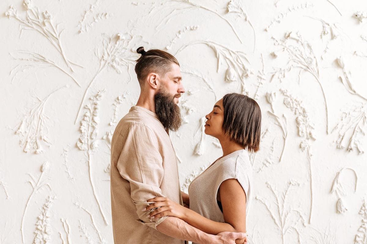 Man and woman facing each other with eyes closed, practicing how to forgive and forget