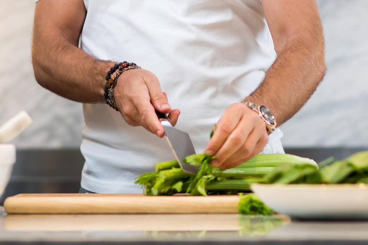 Man chopping one of the best immunity-boosting foods on a cutting board