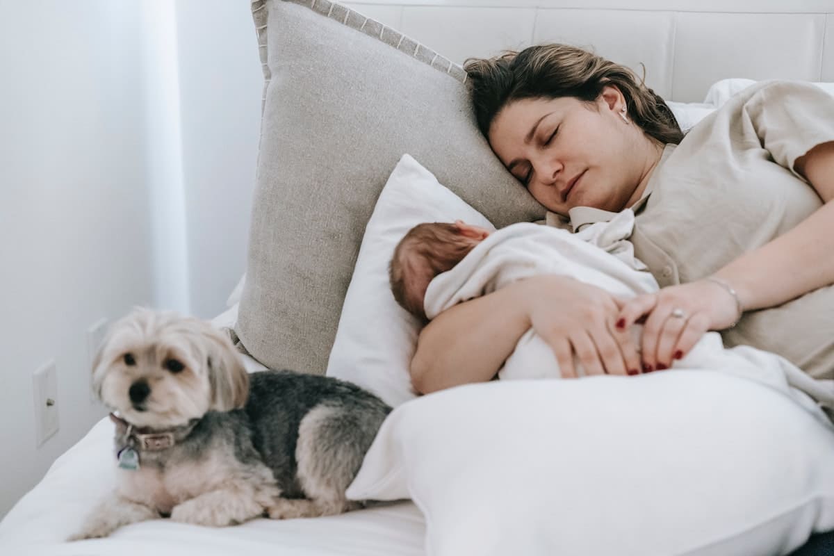 Mother using sleep tip for new parents and sleeping with her newborn