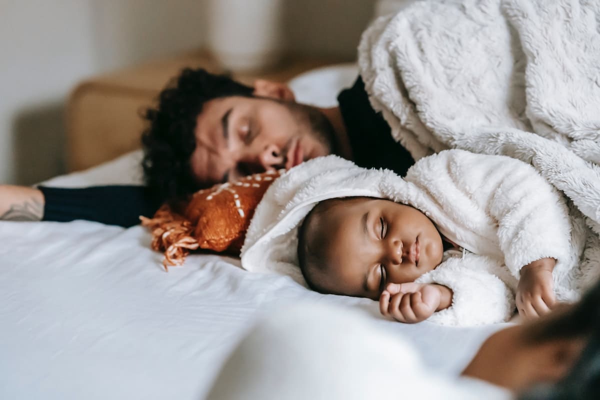 Father using sleep tip for new parents and sleeping with his baby