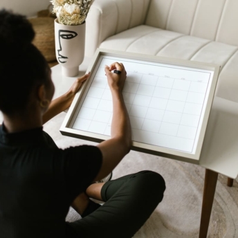 Woman time blocking her calendar on a board