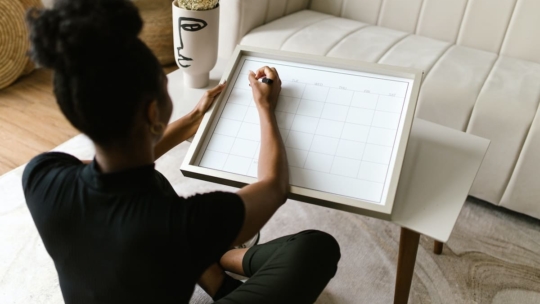 Woman time blocking her calendar on a board