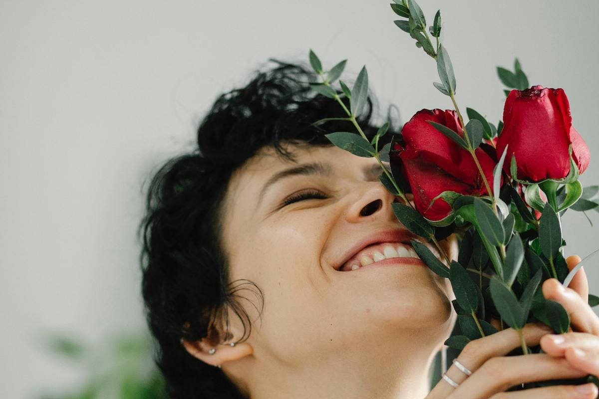 Woman smelling roses as an act of self-love