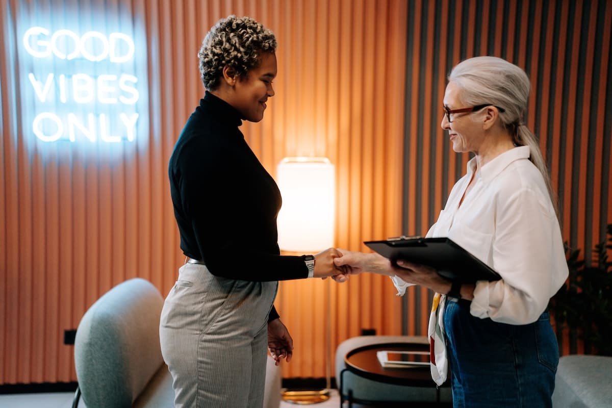 Women shaking hands as a way to show how to build rapport