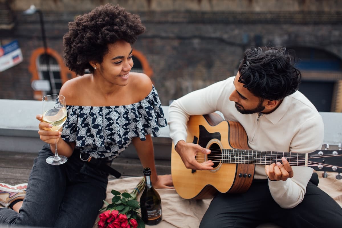 Man playing the guitar for woman on a date