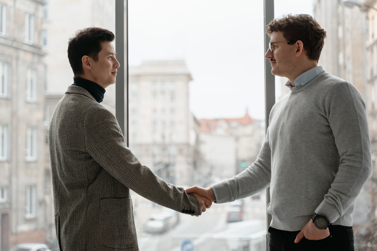 Men shaking hands as a sign of body language in the workplace