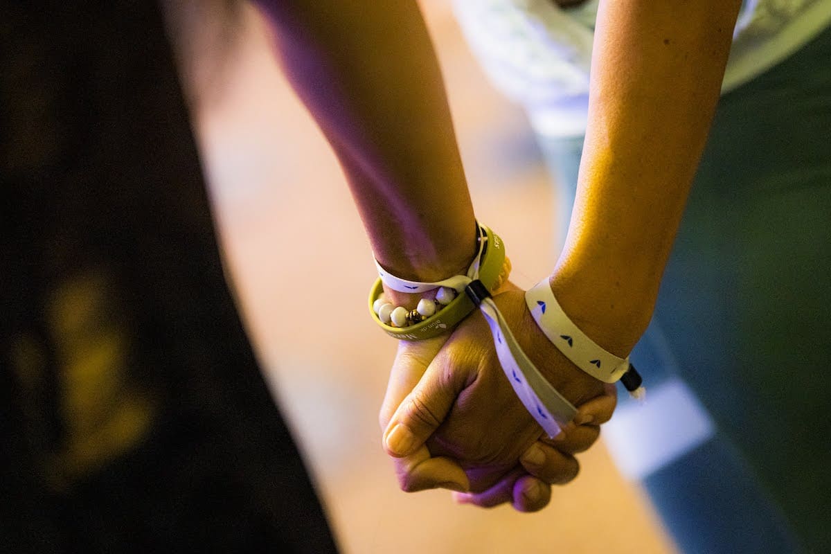 People holding hands at one of the Mindvalley events