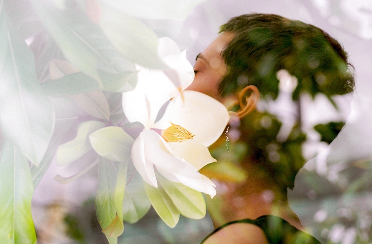 a woman mindfully breathing in the scent of the flowers