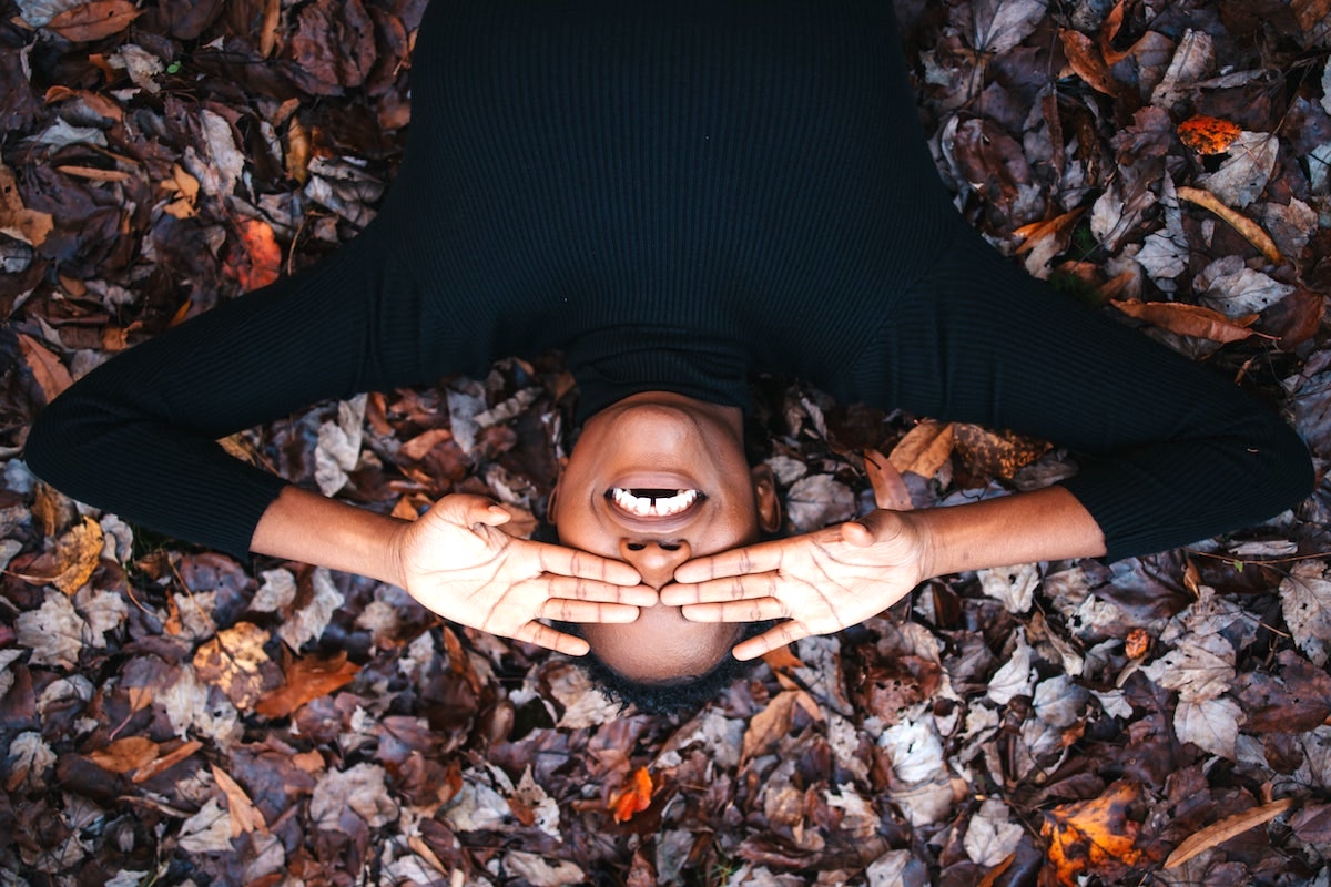 a black woman lying on the ground with her hands on the eyes