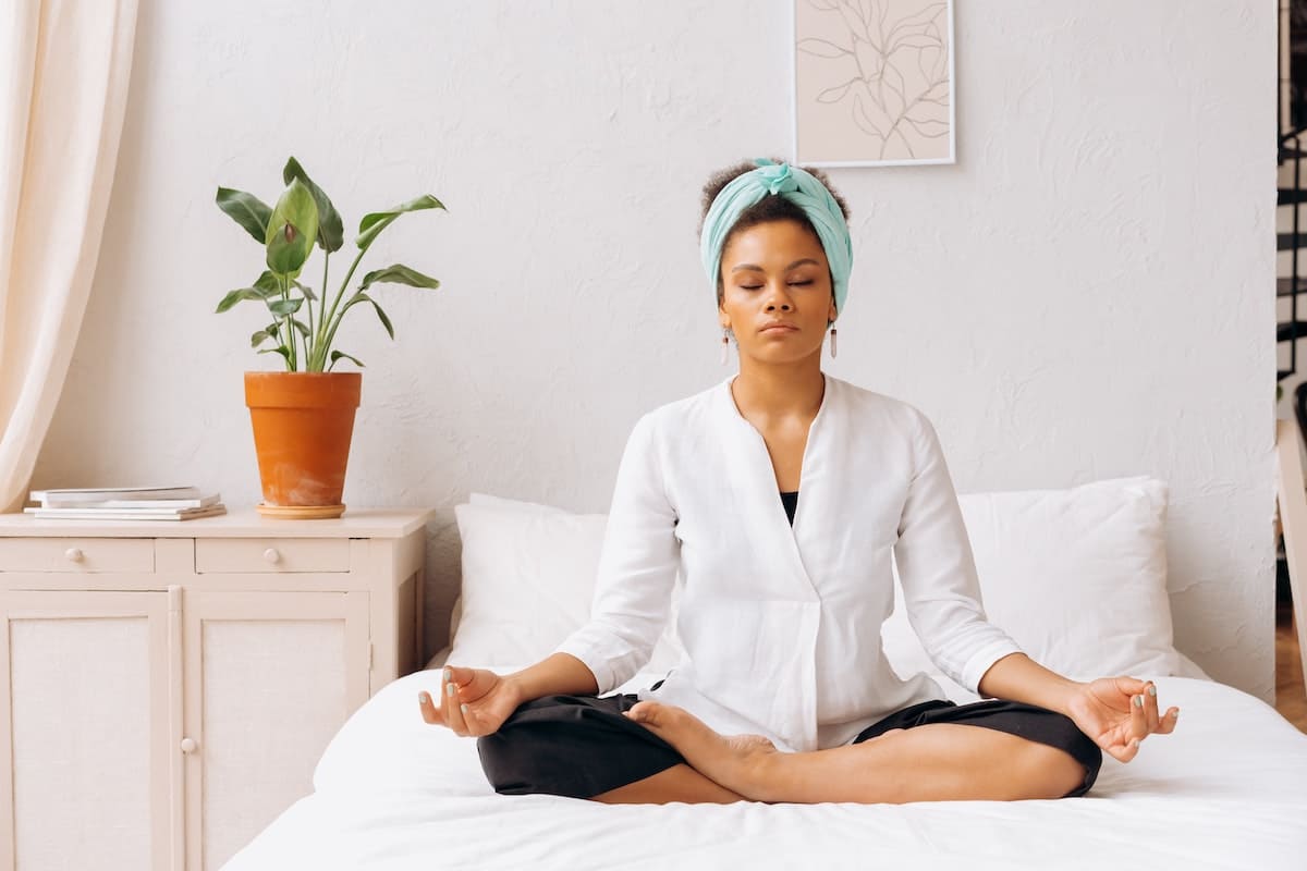 Woman meditating on a bed