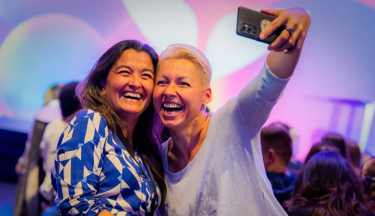 Mindvalley members posing for a selfie at Mindvalley Weekend in Berlin and emulating the question, "Do experiences make us happier than possessions?"